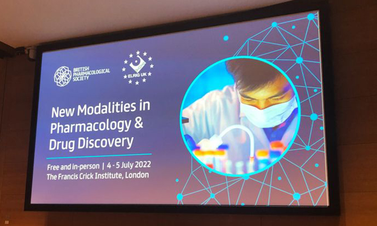 Image showing ELRIG and BPS event poster. Text: New modalities in pharmacology and drug discovery, Free and in-person 4 - 5 July at the Francis Crick Institue London. Image of a scientist and test tubes. Blue background