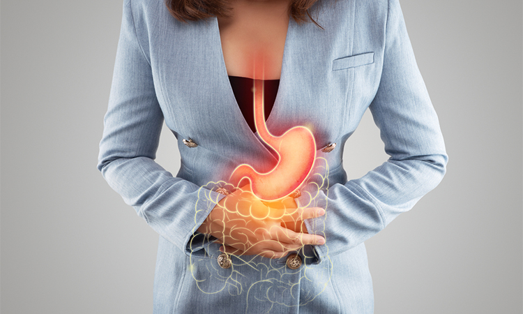 The illustration of stomach and large intestine is on the woman's body against gray background. Acid reflux.