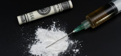 pile of white powder, a syringe filled with brown liquid and a rolled up dollar bill - cocaine use paraphanalia