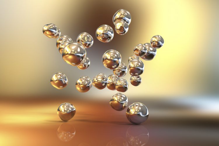 3D illustration of gold nanoparticles falling from above onto a shiny gold surface
