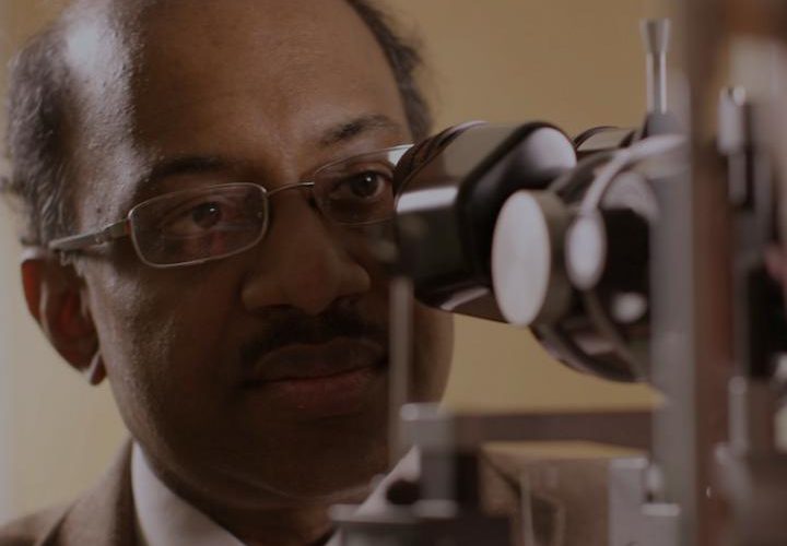 Dr Jayakrishna Ambati looking into a microscope - macular degeneration research [Credit: UVA Health].