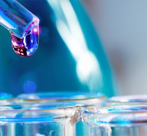 Pipette with transparent drop over glass test tubes