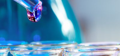 Pipette with transparent drop over glass test tubes