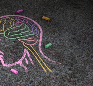 Concept of autism and autistic development disorder as a symbol of a communication and social behavior psychology as a chalk drawing on asphalt in a 3D illustration style.