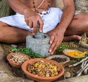 A person preparing ayurvedic medicine in the traditional manner in India