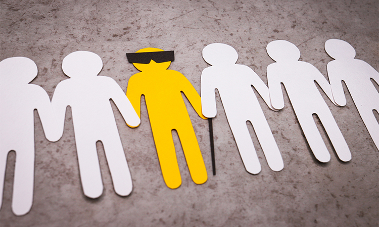 The silhouette of a blind man with a cane and glasses. People stand in a line and support the yellow figure by the hands.
