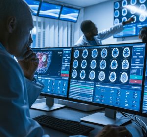 Over the Shoulder Shot of Senior Medical Scientist Working with CT Brain Scan Images on a Personal Computer in Laboratory.