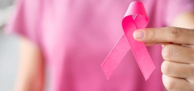 October Breast Cancer Awareness month, Woman in pink T- shirt with hand holding Pink Ribbon for supporting people living and illness. Healthcare, International Women day and World cancer day concept