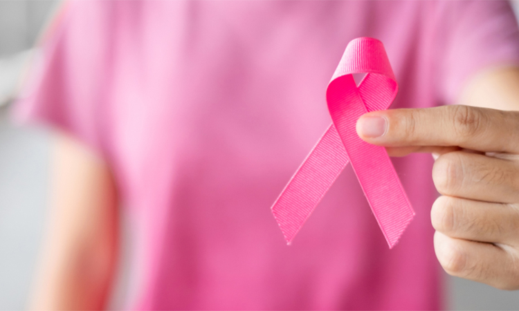 October Breast Cancer Awareness month, Woman in pink T- shirt with hand holding Pink Ribbon for supporting people living and illness. Healthcare, International Women day and World cancer day concept