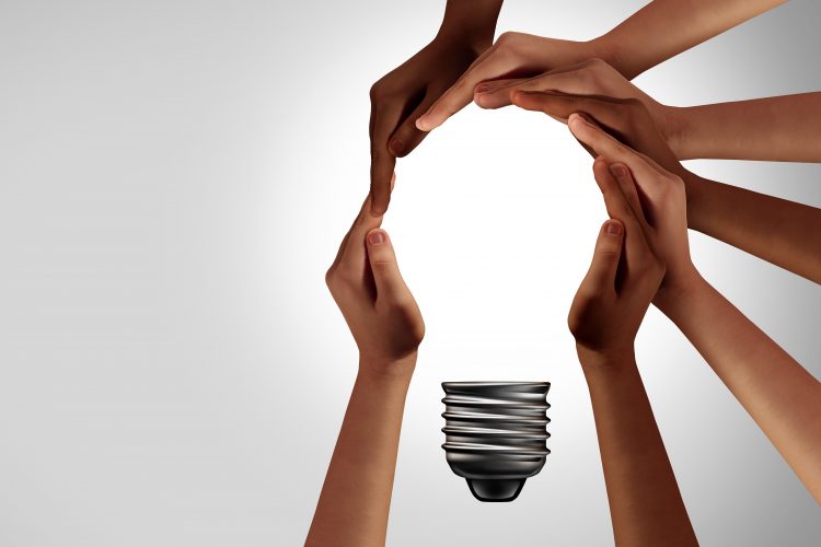 hands coming together to create a lightbulb