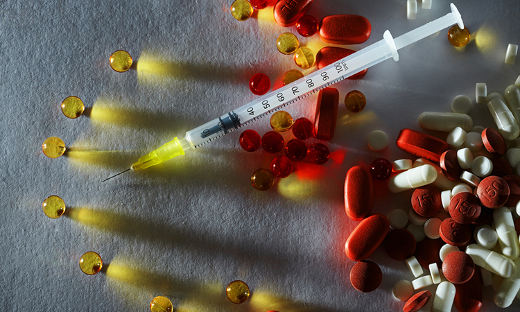 image showing combination of therapies: an injection with yellow, red and white pills