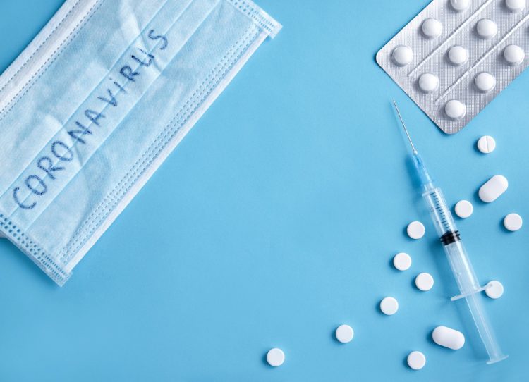 face mask, white tablets and syringe of medication