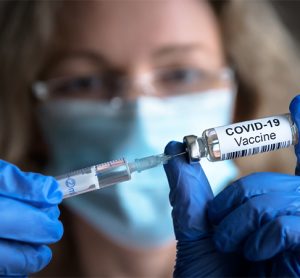 COVID-19 vaccine in researcher hands, female doctor holds syringe and bottle with vaccine for COVID-19