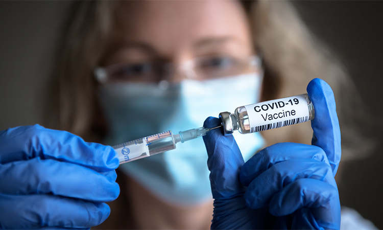 COVID-19 vaccine in researcher hands, female doctor holds syringe and bottle with vaccine for COVID-19