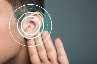 close up of a man's ear with rings like a target over it - idea of drug targets for deafness