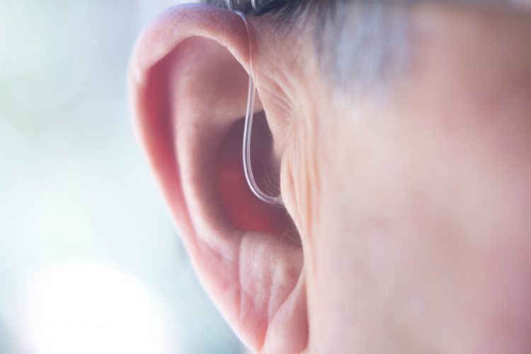 close up of a man's ear with a hearing aid in - idea of deafness