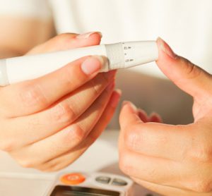 Diabetic woman checking blood sugar level using Glucose Meter