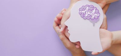 Adult and child hands holding encephalography brain paper cutout