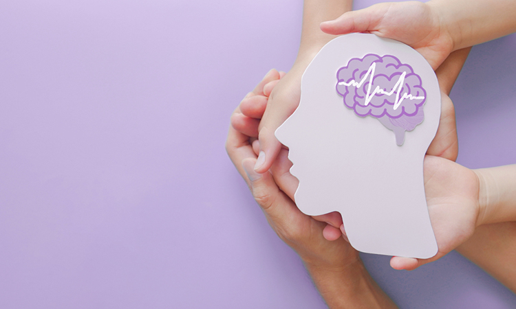 Adult and child hands holding encephalography brain paper cutout