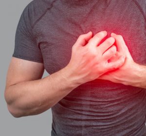 Person clutching chest from acute pain, Heart attack symptom.