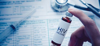 Close up of unknown doctor hand holding an ampule with HIV vaccine text