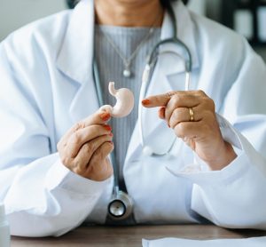 Female doctor holding Intestine in hand on right side.Healthcare hospital service concept stock photo. in background