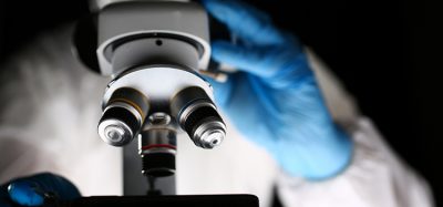 Laboratory Pharmacist Work at Optical Microscope. Scientist Working on Research with Microscopy Metal Lens. Pharmaceutical Lab. Chemist in Coverall Analyzing Experiment with Medical Equipment.