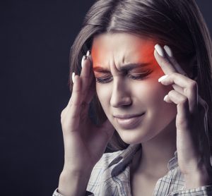person is suffering from a headache against a dark backgroun