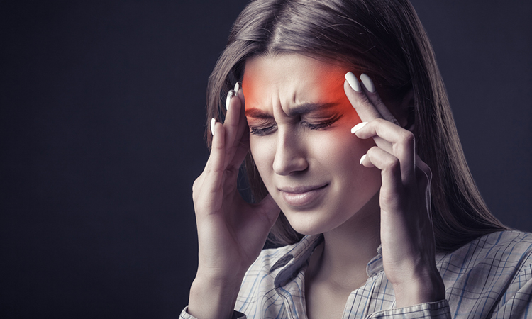 person is suffering from a headache against a dark backgroun