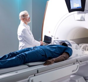 Senior Radiologist Controls MRI with Patient Undergoing Procedure.