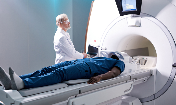 Senior Radiologist Controls MRI with Patient Undergoing Procedure.