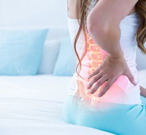 woman holding back with spine highlighted in red