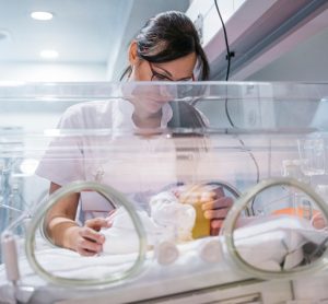 Image showing doctor examining newborn baby in incubator