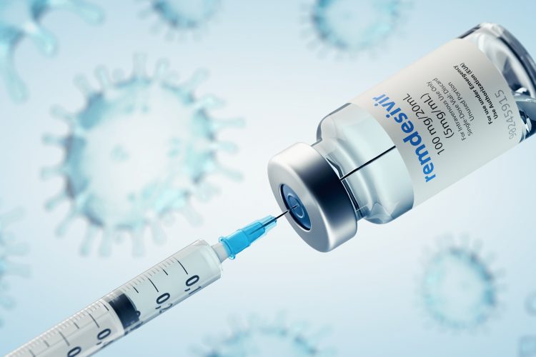 Syringe drawing liquid from a vial labelled 'REMDESIVIR', on a background of abstract SARS-CoV-2 particles [Credit: ffikretow@hotmail.com / Shutterstock.com].