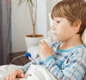 Image showing child with a respiratory syncytial virus, inhaling medication through an inhalation mask.