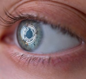 Woman's eye with smart contact lens with digital and biometric implants to scan the ocular retina close up. Concept of future and technology for digital scans
