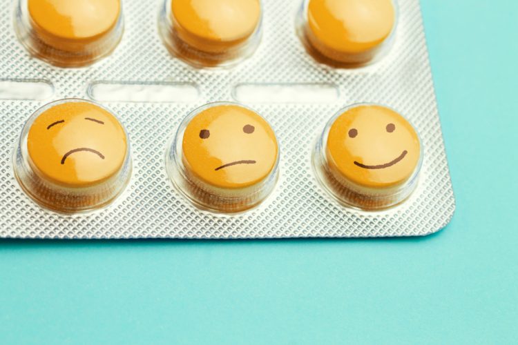 Yellow antidepressant pills with smiley faces drawn on