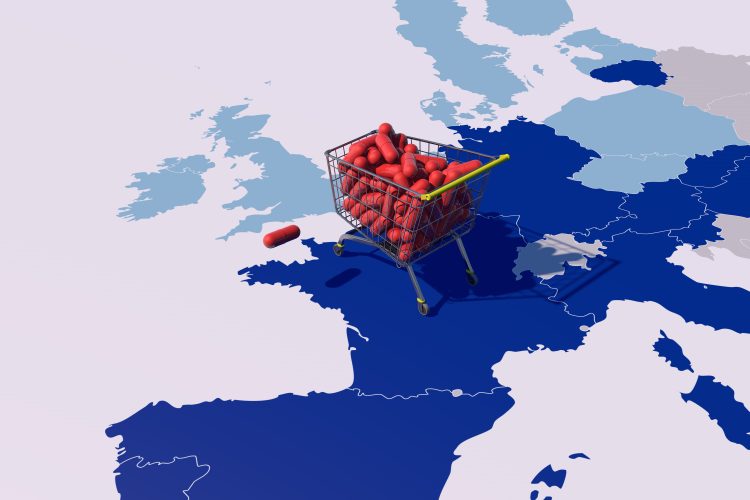 Shopping cart filled with red capsules placed on a map of Europe and the UK, symbolizing access and regulation of medicines.