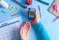 The diabetic measures the level of glucose in the blood. World Diabetes day, 14 November. Diabetes concept. Diabetic supplies on a blue background