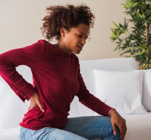 Woman with chronic pain holding back