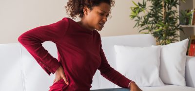 Woman with chronic pain holding back