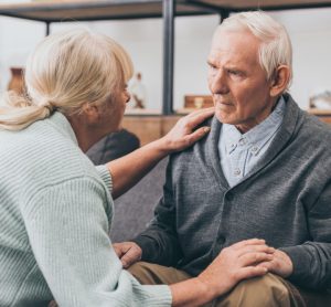Woman holding elderly man's hand