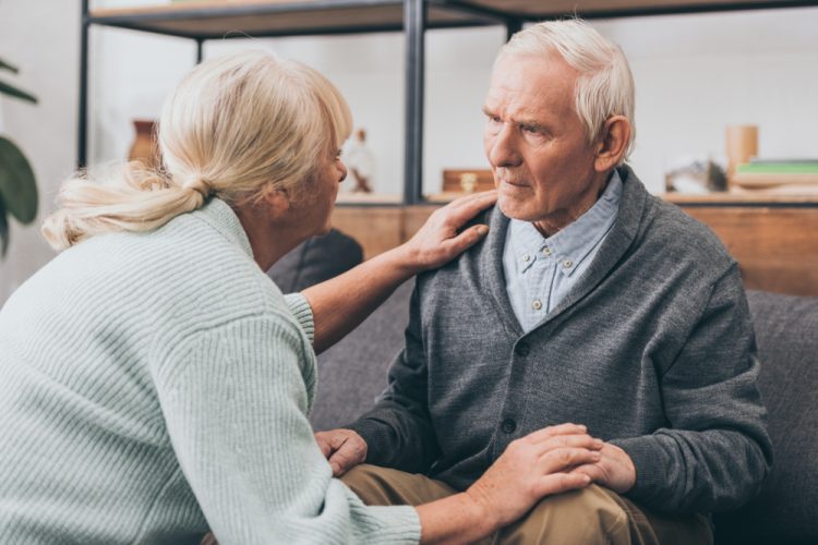 Woman holding elderly man's hand