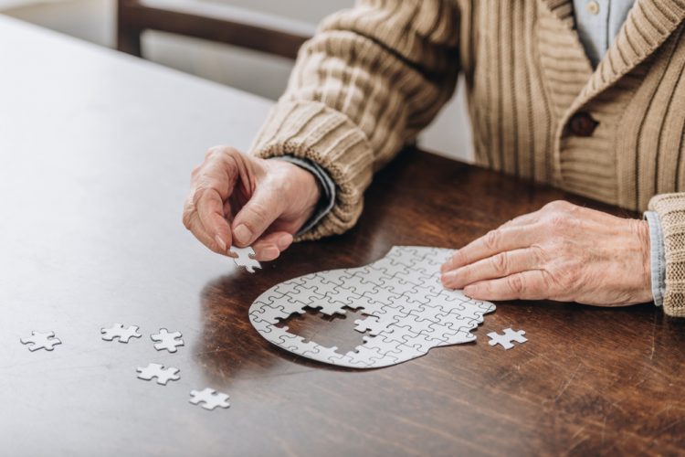 Older man with puzzle in shape of a brain