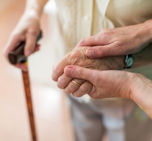 Nurse holding elderly persons hand