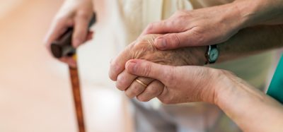 Nurse holding elderly persons hand
