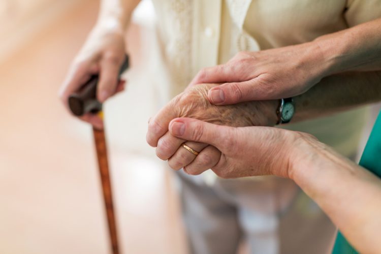 Nurse holding elderly persons hand