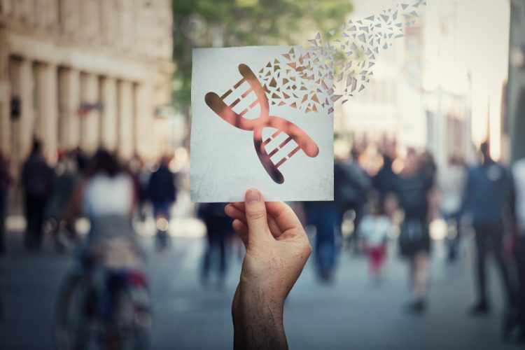 Man holding paper with DNA molecule breaking apart, representing gene editing