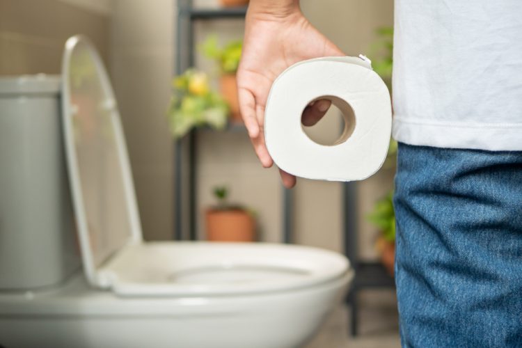 Man holding loo roll in bathroom