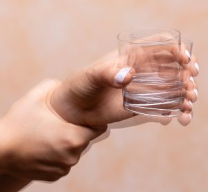 Shaky image of hand holding glass of water, indicating Parkinson's disease